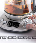 Electric Tea Kettle With Removable Infuser, 9 Preset Brewing Programs, Precise Temperature Control, 2 Hours Keep Warm, Borosilicate Glass, 1.7 Liter Capacity, 1200W Fast Boil For Tea Coffee And Everyday Brew, showing LCD display and temperature dial in use.