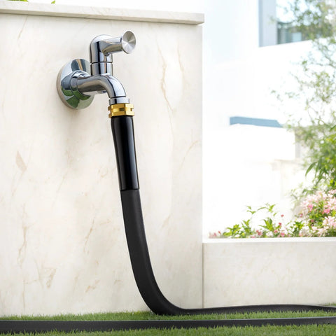 Garden hose, black with brass fittings attached to a chrome wall faucet