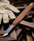 Heavy Duty Long Neck Marking Knife For Woodworking features a steel blade, wooden handle, and leather glove on wood background.