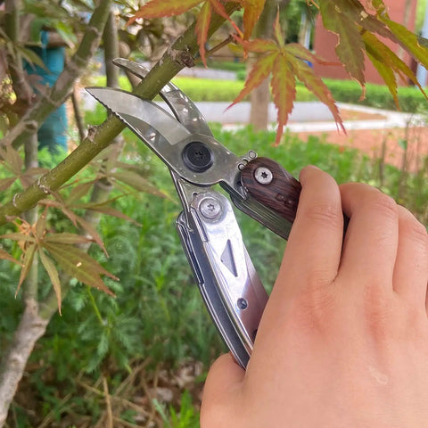 Person using 7 In 1 Garden Pruning Shears Folding Multitool With 8 Inch Professional Garden Scissors to prune a branch.