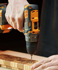 Cordless drill with a 5 mm self-centering hinge tapper core drill bit drilling into a wooden board.