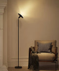 Remote Controlled Floor Lamp With Foot Switch Sky LED Tall Modern Torchiere next to armchair in living room, black finish
