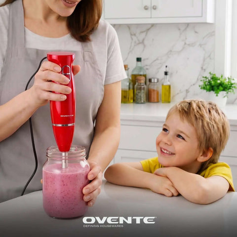 Red Corded Immersion Blender 300W with Two Speeds for Whipping Up Smoothies Sauces and Dips in a Flash, mixing a pink smoothie.