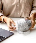 Person wrapping item with Bubble Cushioning Roll, 72 Ft Long, 12 Inch Wide, Three Sixteenth Inch Air Bubbles, Perforated Every 12 Inches