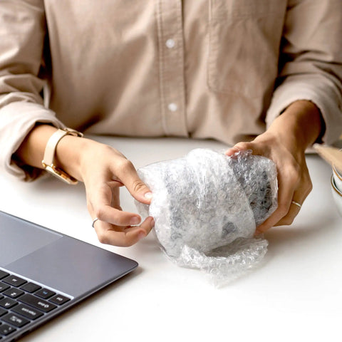 Person wrapping item with Bubble Cushioning Roll, 72 Ft Long, 12 Inch Wide, Three Sixteenth Inch Air Bubbles, Perforated Every 12 Inches