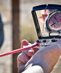 Close-up of Advanced Mirror Compass For Pros And Serious Hikers With Metric UTM Scales And Inch Ruler in use outdoors.