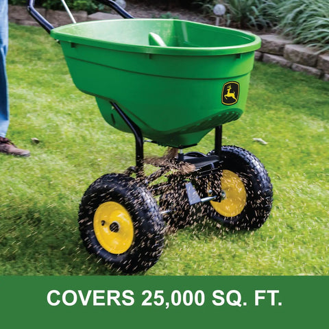 Push Broadcast Spreader With 130 Lb Capacity And Rust Proof Poly Hopper in use on grass, distributing seeds evenly