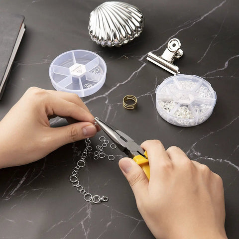 Hands using pliers on chain with Over 1000 Open Jump Rings Kit With 40Pcs 12Mm Lobster Clasps And Jump Ring Opener for jewelry making