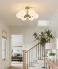 Brushed Gold Sputnik Flush Mount Ceiling Light With Six Milk Glass Globes illuminating a cozy hallway with plants and wood accents.