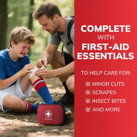Red compact first-aid kit with white cross on forest ground as man tends a boy's knee.