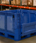 Heavy Duty Collapsible Bulk Box 48x40x33 Inch Plastic Storage Tote with drop doors in warehouse setting.