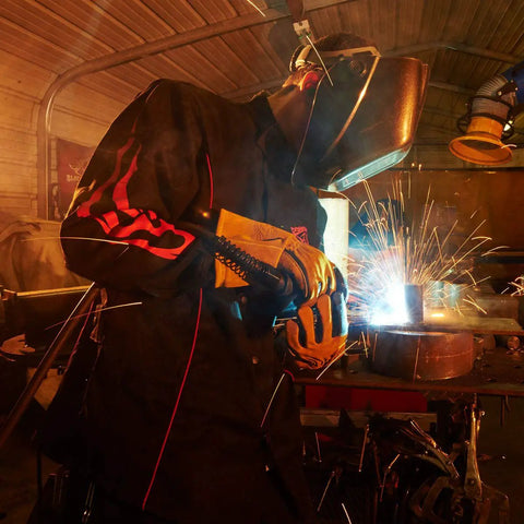Welder wearing Contoured 9 Ounce Flame Resistant Cotton Welding Jacket With Welder's Collar and sparks flying around