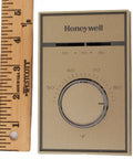 T651A3018 Heat And Cool Thermostat For 120V To 277V Systems shown next to a wooden ruler for size reference