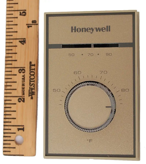 T651A3018 Heat And Cool Thermostat For 120V To 277V Systems shown next to a wooden ruler for size reference