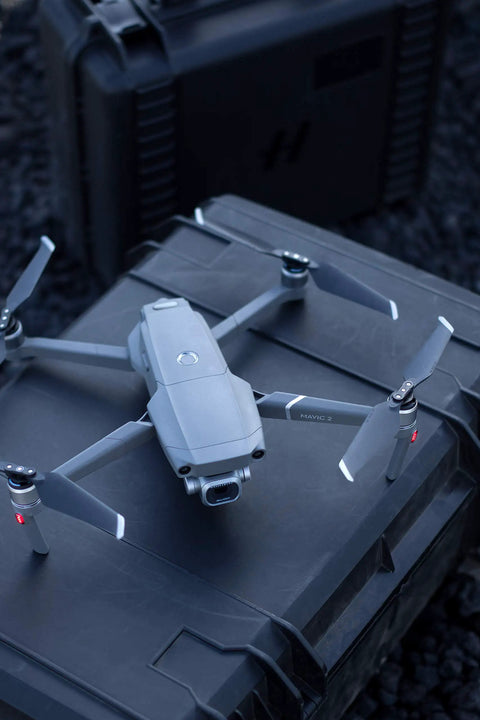 Mavic 2 Pro Drone Quadcopter With Hasselblad Camera, 3 Axis Gimbal, HDR 4K Video resting on a dark case outdoors.