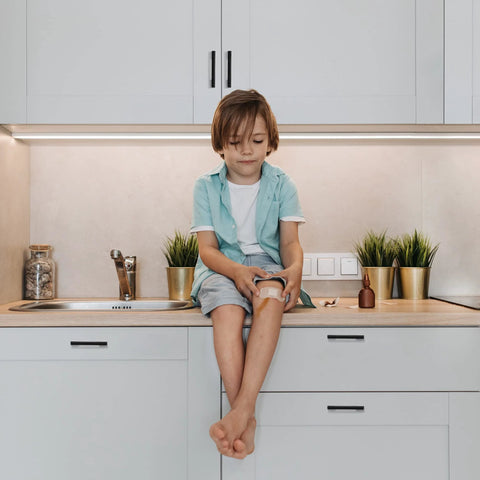 Child sitting on kitchen counter next to cabinets with 3 Inch Wide Foot Cabinet Pulls 10 Pack Matte Black Cabinet Handles installed