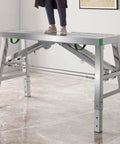 Adjustable Steel Scaffolding Ladder Workbench Built Like A Tank With 800 Lbs Load Capacity And Non Slip Pads For Heavy Duty Construction DIY Projects Converts To Rugged Portable Scaffold Platform. Person standing on silver workbench.