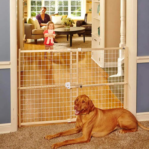 Extra Wide Wooden Baby Gate With Wire Mesh For Doorways Pressure Mounted Adjustable From About 29 To 50 Inches Wide And 31 Inches Tall Kid Safe Play Space blocking doorway; child and dog visible