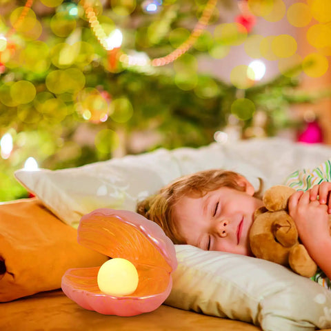 Child sleeping by Ocean Inspired Pearl Light LED Seashell Lamp for Nightstand and Desk Ceramic Shell Glow Portable Pink Night Light