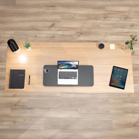 Top view of office desk setup with laptop, notebook, and Black 28 Inch Standing Desk Converter Sit To Stand Monitor Riser