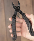 Hand holding Bike Chain Master Link Pliers 2 In 1 Tool for Easy No Sweat Quick Link Removal and Replacement, black rubber grip
