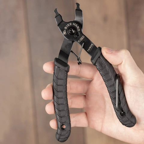 Hand holding Bike Chain Master Link Pliers 2 In 1 Tool for Easy No Sweat Quick Link Removal and Replacement, black rubber grip