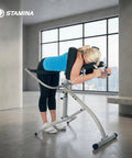 Woman using InLine Traction Control System For Back Pain Relief And Spine Decompression in a home gym setting.