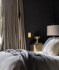 Meadows Light Switch Cover Plate In Greek Revival Style in bedroom with brass finish, decorative border, and curved edges.