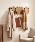 Premium Acacia Wood Wall Mounted Coat Rack With Eight Retractable Hooks holding a coat and bag in an entryway.