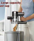 Woman emptying dust cup from cordless vacuum cleaner with 450W motor and 40KPa max suction, 50 minute run time, into bin