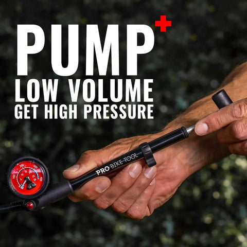 Hand holding High Pressure 300 PSI Shock Pump for mountain and road bikes with precise dial gauge and T handle.