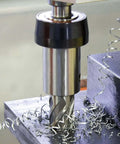 Annular cutter in magnetic drill, close-up view; silver high-speed steel tool with spiral flutes and metal shavings