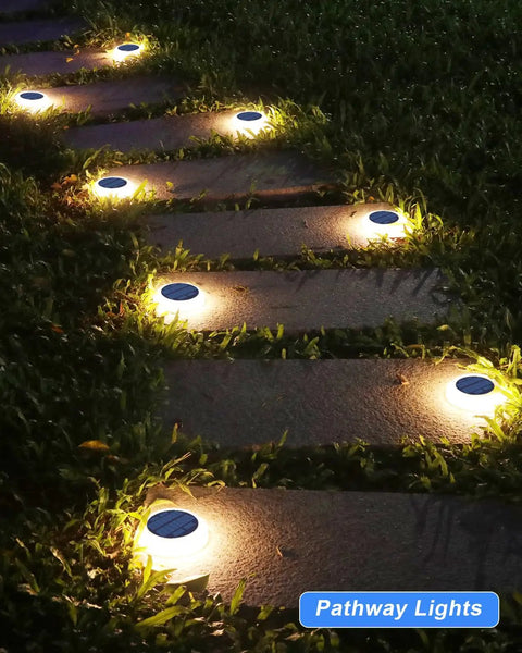 Solar Step Lights Outdoor Waterproof 4 Pack Warm White Flat Lights illuminating a garden pathway at night.