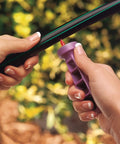Hands holding a tool for Drip Irrigation Repair And Expansion Kit With 102 Universal Parts, 100 Feet Self Dispensing Tubing