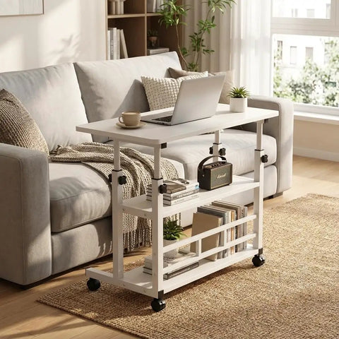 Height Adjustable Standing Desk With Rock Solid Swivel Casters And Sturdy Mobile Computer Workstation beside a sofa, featuring a laptop and coffee.
