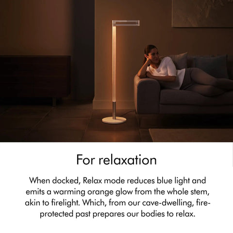 Solarcycle Morph Floor Light CF06 Smart Multi Mode Lamp in Relax Mode with warm orange glow in a modern living room setting.