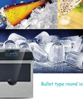 Badass Compact Countertop Ice Maker Churns Fifty Five Pounds Of Crisp Round Cubes Daily With Sleek Top Fill Lid and Speed Freeze System seen with bullet type round ice.