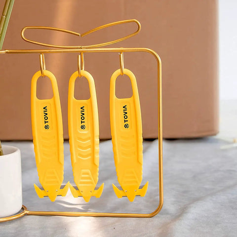 Three yellow box cutters hanging on a stand, featuring double-sided concealed blades, labeled with 'TOYUA'. Ideal for safe package opening.