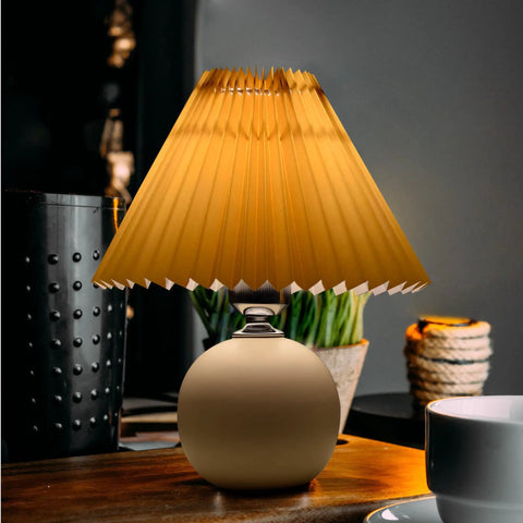 Pleated Ceramic Table Lamp With Tricolor Led Bulb For Living Room Decor on a wooden table with warm light glow