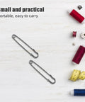 Bold 50pcs Heavy Duty Iron Safety Pins For Sweater Clips and Jacket Closures Plus Retro Brooches For DIY Crafters and Industrial Work Projects That Actually Stay Put No More Dropped Items, gray metal pins on a sewing workspace.