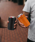Two people holding cans in Stainless Steel 12oz Vacuum Insulated Can And Bottle Cooler Keeps Ya Drinks Ice Cold With Double Wall Construction Copper Plated Chiller Metal Cooler For Cans And Bottles Black Finish.