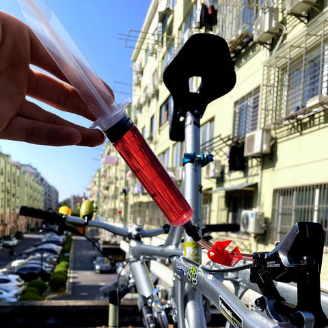 Using an All In One Hydraulic Brake Bleed Kit With 120ml Mineral Oil, Funnel, Syringes And Adapters For MTB And Road Disc Brakes in outdoor setting