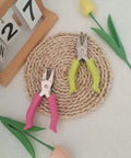 Soft Grip Hole Punch Set with pink and green handles displayed on a woven mat, featuring 1/4 inch and 1/8 inch sizes for scrapbooks.