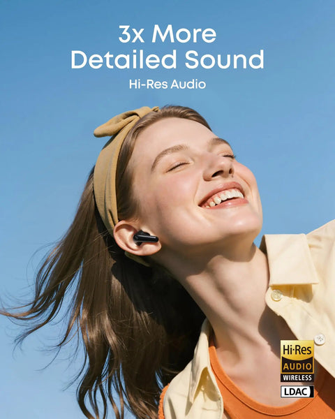 Smiling person wearing Adaptive Noise Cancelling Wireless Earbuds With Real Time Translation And Hi Res LDAC Audio outdoors