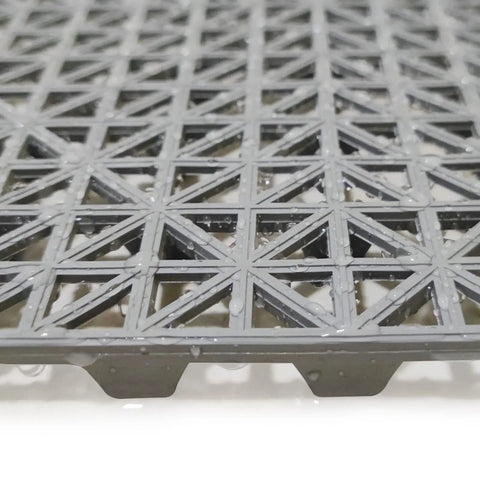 Close-up of gray 12 Pack Modular Interlocking Cushion Rubber Floor Mats 11.6 Inch Square Tiles showing drainage design.