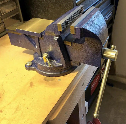 6 Inch General Purpose Bench Vise with 120 Degree Swivel Base and 5 Inch Jaw Opening, 3 Inch Throat, 30,000 PSI Gray Cast Iron on workbench