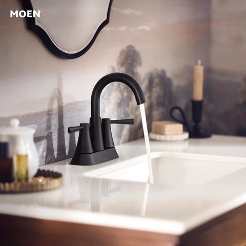 Ronan Matte Black Two-Handle 4-Inch Centerset Modern Bathroom Faucet With Push-Down Drain installed on a sink.