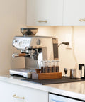 Espresso machine setup with Bottomless 54mm Portafilter With Walnut And Stainless For Breville Espresso Machines on kitchen counter.