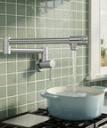 Double Joint Swing Arm Pot Filler Faucet With Wall Mount Folding Kitchen Spout No Lead Stainless Steel Brushed Nickel Finish Two Handle Design NSF Certified Built To Last installed over a stove filling a pot