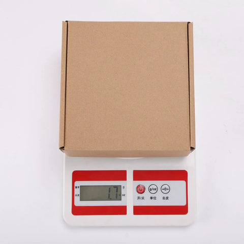 Rock Solid 50 Pack Small Shipping Boxes 6x6x2 Inch Brown Kraft Corrugated Cardboard Mailing Cartons on a scale weighing 1.7 ounces.